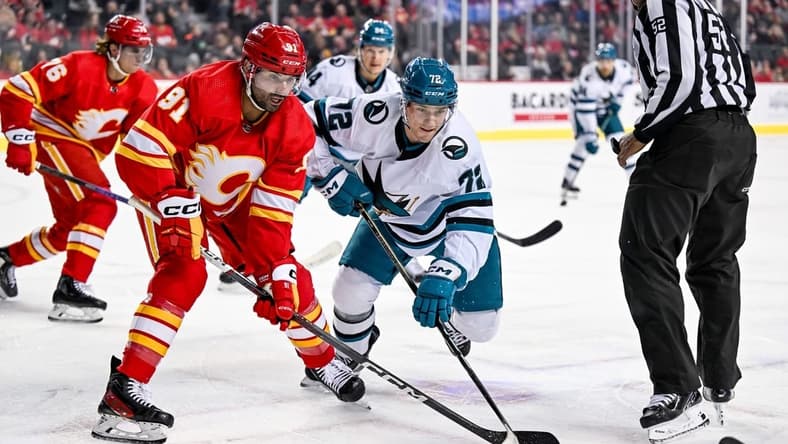 Feb 15, 2024; Calgary, Alberta, CAN; Calgary Flames center Nazem Kadri (91) and San Jose Sharks left wing William Eklund (72) take a face-off during the first period at Scotiabank Saddledome. Mandatory Credit: Brett Holmes-USA TODAY Sports