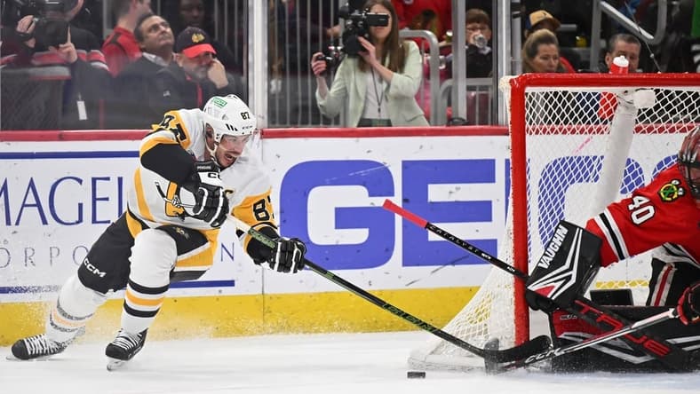 Feb 15, 2024; Chicago, Illinois, USA; Pittsburgh Penguins forward Sidney Crosby (87) attempts a shot on Chicago Blackhawks goaltender Arvid Soderblom (40) in the second period at United Center. Mandatory Credit: Jamie Sabau-USA TODAY Sports
