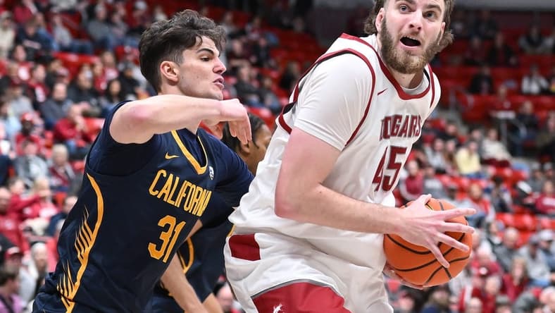 Feb 15, 2024; Pullman, Washington, USA; Washington State Cougars forward Oscar Cluff (45) shoots the ball against California Golden Bears guard Gus Larson (31) in the first half at Friel Court at Beasley Coliseum. Mandatory Credit: James Snook-USA TODAY Sports
