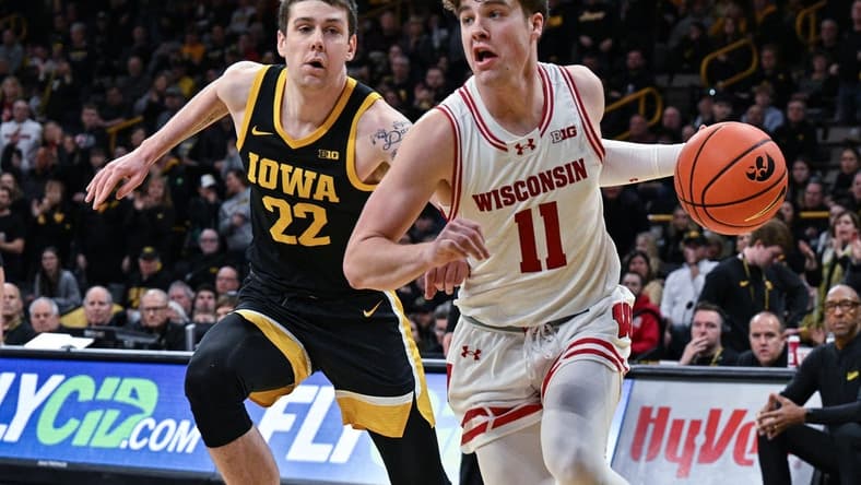 Feb 17, 2024; Iowa City, Iowa, USA; Wisconsin Badgers guard Max Klesmit (11) goes to the basket as Iowa Hawkeyes forward Patrick McCaffery (22) defends during the first half at Carver-Hawkeye Arena. Mandatory Credit: Jeffrey Becker-USA TODAY Sports
