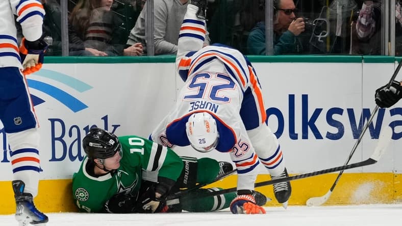 Feb 17, 2024; Dallas, Texas, USA; Edmonton Oilers defenseman Darnell Nurse (25) is checked by Dallas Stars center Ty Dellandrea (10) during the first period at American Airlines Center. Mandatory Credit: Chris Jones-USA TODAY Sports