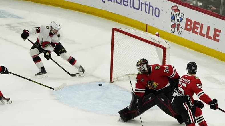 Feb 17, 2024; Chicago, Illinois, USA; Ottawa Senators center Tim Stutzle (18) scores a goal on Chicago Blackhawks goalie Petr Mrazek (34) during the first period at United Center. Mandatory Credit: David Banks-USA TODAY Sports