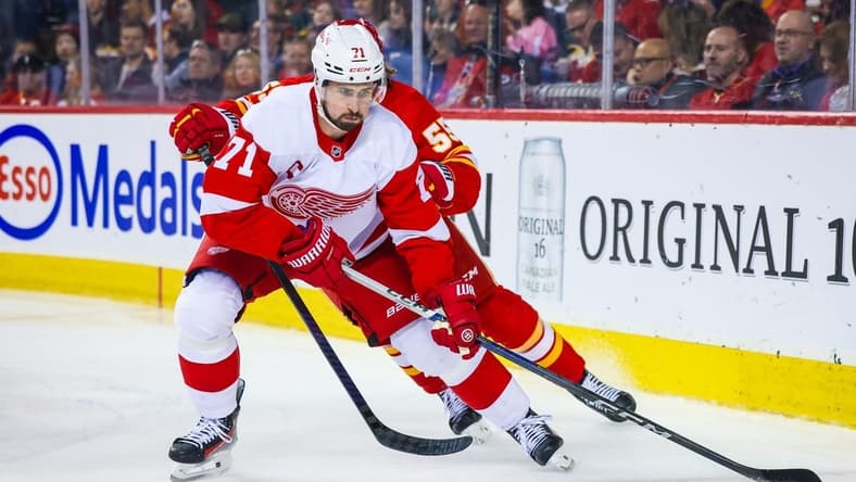 Feb 17, 2024; Calgary, Alberta, CAN; Detroit Red Wings center Dylan Larkin (71) and Calgary Flames defenseman Noah Hanifin (55) battles for the puck during the second period at Scotiabank Saddledome. Mandatory Credit: Sergei Belski-USA TODAY Sports