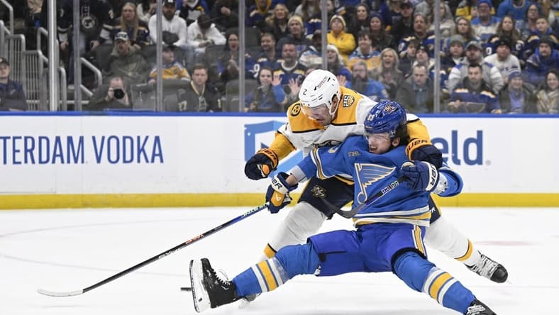 Feb 17, 2024; St. Louis, Missouri, USA; St. Louis Blues left wing Jake Neighbours (63) is awarded a penalty shot after being taken down by Nashville Predators defenseman Luke Schenn (2) during the second period at Enterprise Center. Mandatory Credit: Jeff Le-USA TODAY Sports