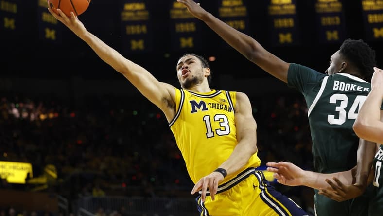 Feb 17, 2024; Ann Arbor, Michigan, USA; Michigan Wolverines forward Olivier Nkamhoua (13) shoots on Michigan State Spartans forward Xavier Booker (34) in the first half at Crisler Center. Mandatory Credit: Rick Osentoski-USA TODAY Sports