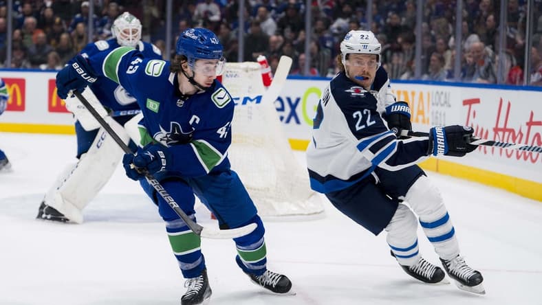 Feb 17, 2024; Vancouver, British Columbia, CAN; Vancouver Canucks defenseman Quinn Hughes (43) battles with Winnipeg Jets forward Mason Appleton (22) in the first period at Rogers Arena. Mandatory Credit: Bob Frid-USA TODAY Sports