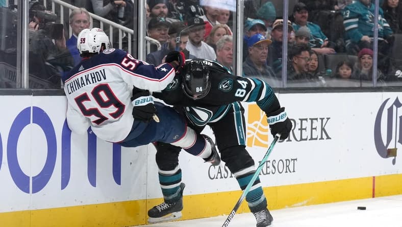 Feb 17, 2024; San Jose, California, USA; San Jose Sharks defenseman Jan Rutta (84) checks Columbus Blue Jackets right wing Yegor Chinakhov (59) during the first period at SAP Center at San Jose. Mandatory Credit: Darren Yamashita-USA TODAY Sports