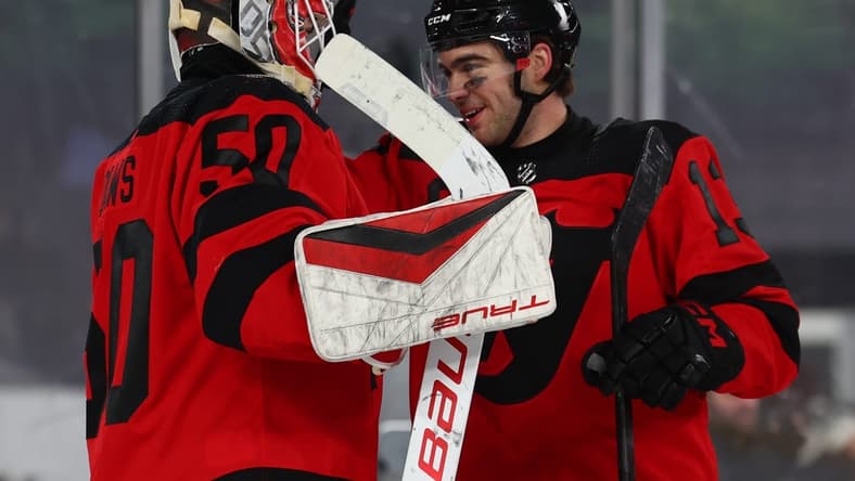 Feb 17, 2024; East Rutherford, New Jersey, USA; New Jersey Devils goaltender Nico Daws (50) and center Nico Hischier (13) celebrate their win over the Philadelphia Flyers in a Stadium Series ice hockey game at MetLife Stadium. Mandatory Credit: Ed Mulholland-USA TODAY Sports