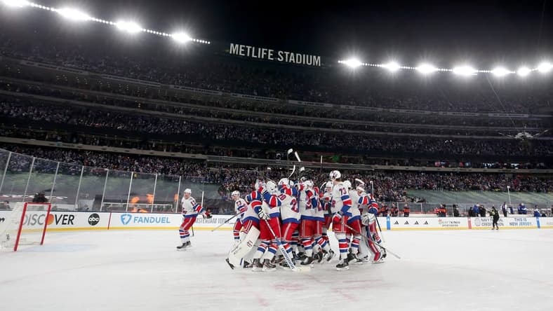 Feb 18, 2024; East Rutherford, New Jersey, USA; New York Rangers players celebrate after defeating the New York Islanders during the overtime period of a Stadium Series ice hockey game at MetLife Stadium. Mandatory Credit: Brad Penner-USA TODAY Sports