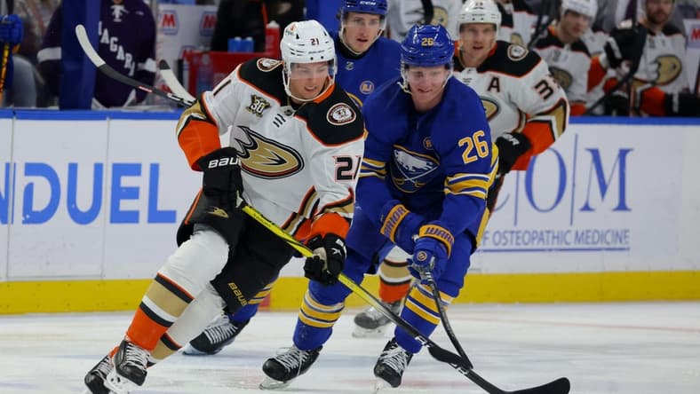 Feb 19, 2024; Buffalo, New York, USA; Anaheim Ducks center Isac Lundestrom (21) looks to control the puck as Buffalo Sabres defenseman Rasmus Dahlin (26) defends during the first period at KeyBank Center. Mandatory Credit: Timothy T. Ludwig-USA TODAY Sports