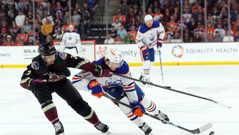 Feb 19, 2024; Tempe, Arizona, USA; Arizona Coyotes defenseman Josh Brown (3) checks Edmonton Oilers center Ryan McLeod (71) during the second period at Mullett Arena. Mandatory Credit: Joe Camporeale-USA TODAY Sports