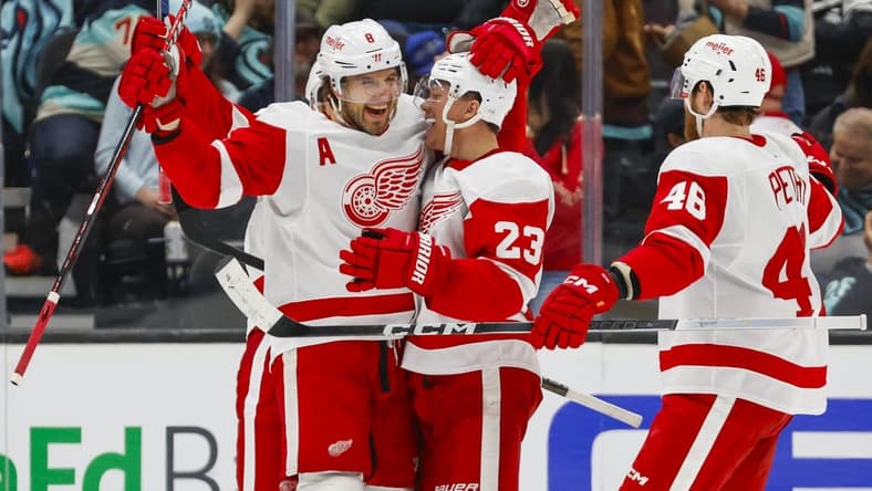 Feb 19, 2024; Seattle, Washington, USA; Seattle Kraken left wing Jared McCann (19) celebrates with left wing Lucas Raymond (23) after scoring a goal against the Detroit Red Wings during the second period at Climate Pledge Arena. Mandatory Credit: Joe Nicholson-USA TODAY Sports