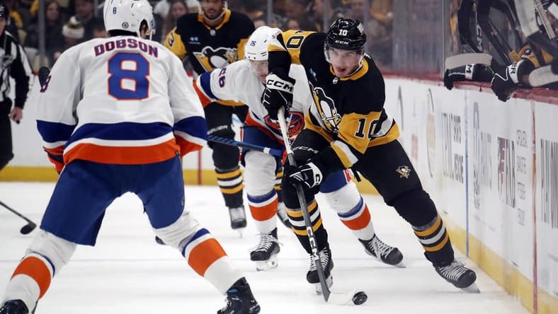 Feb 20, 2024; Pittsburgh, Pennsylvania, USA; Pittsburgh Penguins left wing Drew O'Connor (10) skates up ice with the puck as New York Islanders defenseman Noah Dobson (8) defends during the first period  at PPG Paints Arena. Mandatory Credit: Charles LeClaire-USA TODAY Sports