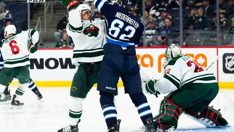 Feb 20, 2024; Winnipeg, Manitoba, CAN; Winnipeg Jets forward Nino Niederreiter (62) jostles for position with Minnesota Wild defenseman Alex Goligoski (33) during the second period at Canada Life Centre. Mandatory Credit: Terrence Lee-USA TODAY Sports