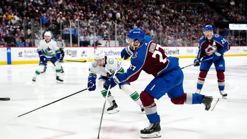 Feb 20, 2024; Denver, Colorado, USA; Colorado Avalanche left wing Jonathan Drouin (27) shoots the puck in the second period against the Vancouver Canucks at Ball Arena. Mandatory Credit: Ron Chenoy-USA TODAY Sports