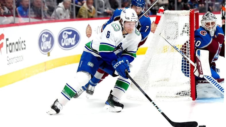 Feb 20, 2024; Denver, Colorado, USA; Vancouver Canucks right wing Brock Boeser (6) skates past Colorado Avalanche defenseman Devon Toews (7) in the third period at Ball Arena. Mandatory Credit: Ron Chenoy-USA TODAY Sports