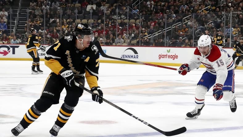 Feb 22, 2024; Pittsburgh, Pennsylvania, USA; Pittsburgh Penguins center Evgeni Malkin (71) skates with the puck as Montreal Canadiens center Alex Newhook (15) chases during the first period at PPG Paints Arena. Mandatory Credit: Charles LeClaire-USA TODAY Sports