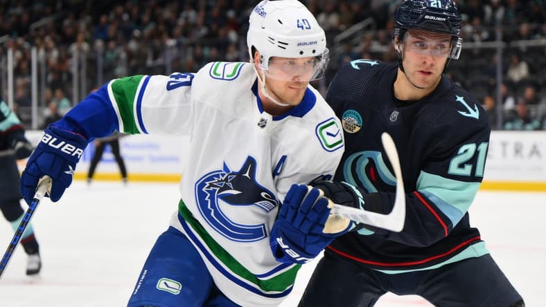 Feb 22, 2024; Seattle, Washington, USA; Vancouver Canucks center Elias Pettersson (40) and Seattle Kraken center Alex Wennberg (21) during the first period at Climate Pledge Arena. Mandatory Credit: Steven Bisig-USA TODAY Sports