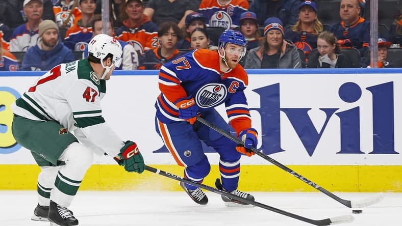 Feb 23, 2024; Edmonton, Alberta, CAN; Edmonton Oilers forward Connor McDavid (97) carries the puck around Minnesota Wild defensemen Declan Chisholm (47) during the first period at Rogers Place. Mandatory Credit: Perry Nelson-USA TODAY Sports