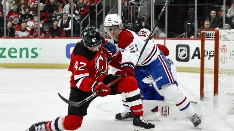 Feb 24, 2024; Newark, New Jersey, USA; New Jersey Devils center Curtis Lazar (42) skates with the puck while being defended by Montreal Canadiens defenseman Kaiden Guhle (21) during the second period at Prudential Center. Mandatory Credit: John Jones-USA TODAY Sports