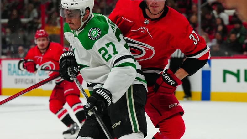 Feb 24, 2024; Raleigh, North Carolina, USA; Dallas Stars left wing Mason Marchment (27) checks Carolina Hurricanes right wing Andrei Svechnikov (37) during the first period at PNC Arena. Mandatory Credit: James Guillory-USA TODAY Sports