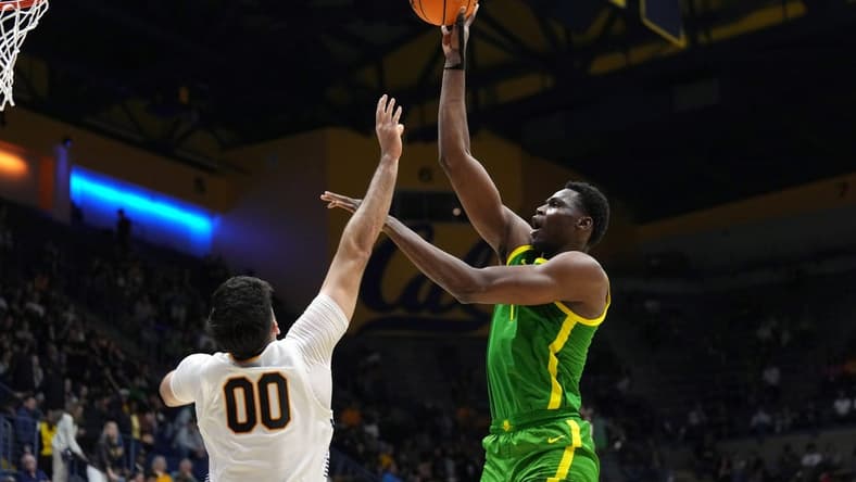 Feb 24, 2024; Berkeley, California, USA; Oregon Ducks center N'Faly Dante (right) shoots against California Golden Bears forward Fardaws Aimaq (00) during the second half at Haas Pavilion. Mandatory Credit: Darren Yamashita-USA TODAY Sports