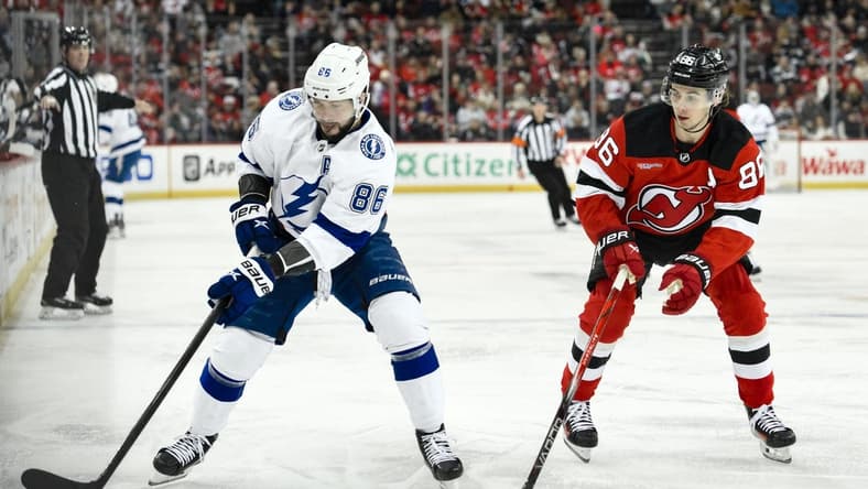 Feb 25, 2024; Newark, New Jersey, USA; Tampa Bay Lightning right wing Nikita Kucherov (86) skates with the puck while being defended by New Jersey Devils center Jack Hughes (86) during the first period at Prudential Center. Mandatory Credit: John Jones-USA TODAY Sports