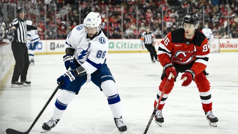 Feb 25, 2024; Newark, New Jersey, USA; Tampa Bay Lightning right wing Nikita Kucherov (86) skates with the puck while being defended by New Jersey Devils center Jack Hughes (86) during the first period at Prudential Center. Mandatory Credit: John Jones-USA TODAY Sports