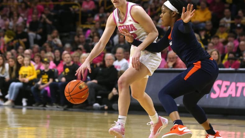 Iowa's Caitlin Clark (22) dribbles as Illinois s Makira Cook (3) defends Saturday, Feb. 24, 2024 at Carver-Hawkeye Arena.