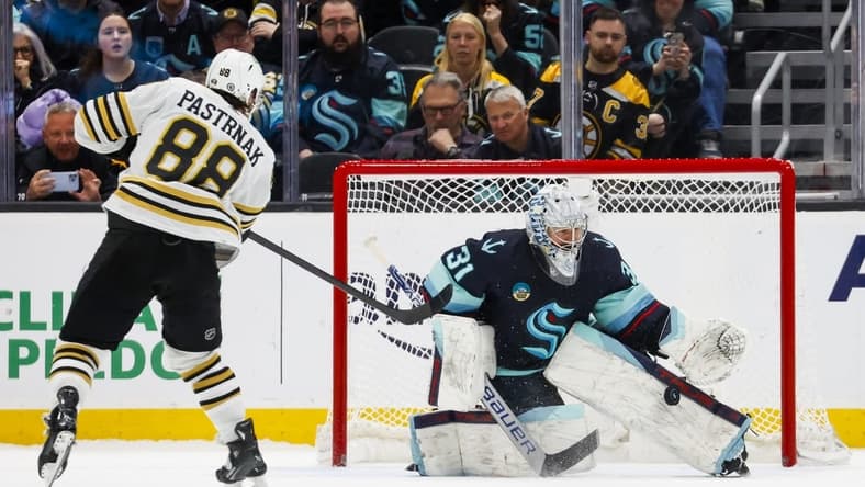 Feb 26, 2024; Seattle, Washington, USA; Seattle Kraken goaltender Philipp Grubauer (31) makes a save against Boston Bruins right wing David Pastrnak (88) during an overtime shootout at Climate Pledge Arena. Mandatory Credit: Joe Nicholson-USA TODAY Sports