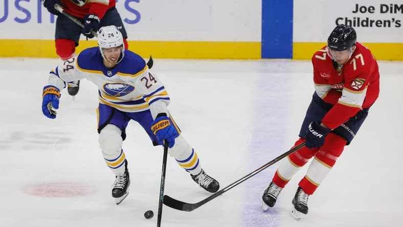 Feb 27, 2024; Sunrise, Florida, USA; Buffalo Sabres center Dylan Cozens (24) protects the puck from Florida Panthers defenseman Niko Mikkola (77) during the first period at Amerant Bank Arena. Mandatory Credit: Sam Navarro-USA TODAY Sports