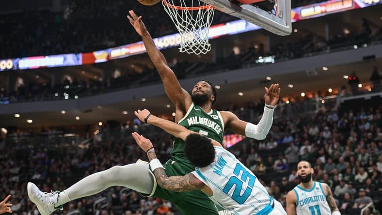 Feb 27, 2024; Milwaukee, Wisconsin, USA; Milwaukee Bucks guard Malik Beasley (5) takes a shot against Charlotte Hornets guard Tre Mann (23) in the first quarter at Fiserv Forum. Mandatory Credit: Benny Sieu-USA TODAY Sports