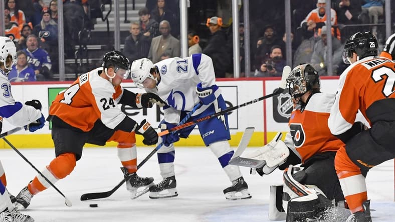Feb 27, 2024; Philadelphia, Pennsylvania, USA; Tampa Bay Lightning center Brayden Point (21) and Philadelphia Flyers defenseman Nick Seeler (24) battle for the puck in front of goaltender Samuel Ersson (33) during the second period at Wells Fargo Center. Mandatory Credit: Eric Hartline-USA TODAY Sports