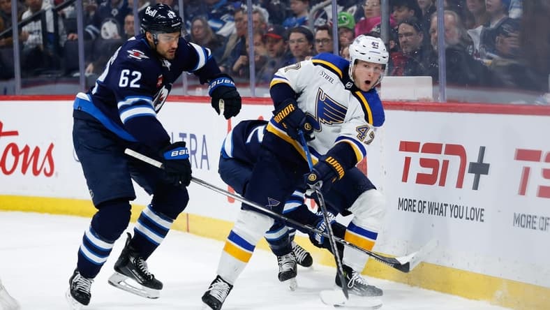Feb 27, 2024; Winnipeg, Manitoba, CAN; St. Louis Blues defenseman Torey Krug (47) makes a pass against Winnipeg Jets forward Nino Niederreiter (62) during the second period at Canada Life Centre. Mandatory Credit: Terrence Lee-USA TODAY Sports
