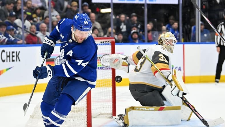Feb 27, 2024; Toronto, Ontario, CAN; Toronto Maple Leafs defenseman Morgan Rielly (44) chases the puck after a save and rebound from Vegas Golden Knights goalie Adin Hill (33) in the third period at Scotiabank Arena. Mandatory Credit: Dan Hamilton-USA TODAY Sports