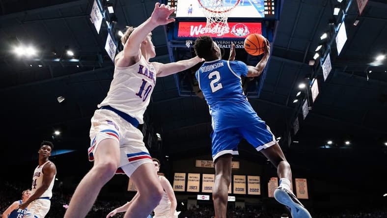 Feb 27, 2024; Lawrence, Kansas, USA; Brigham Young Cougars guard Jaxson Robinson (2) shoots as Kansas Jayhawks guard Johnny Furphy (10) defends during the second half at Allen Fieldhouse. Mandatory Credit: Denny Medley-USA TODAY Sports