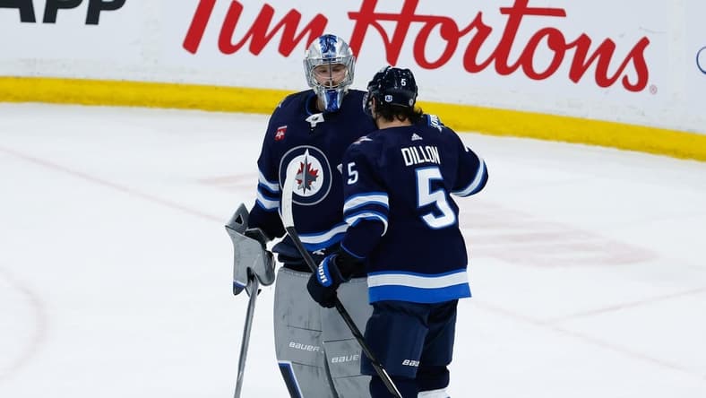 Feb 27, 2024; Winnipeg, Manitoba, CAN; Winnipeg Jets goalie Laurent Boissoit (39) is congratulated by Winnipeg Jets defenseman Brenden Dillon (5) on his win against the St. Louis Blues at the end of the third period at Canada Life Centre. Mandatory Credit: Terrence Lee-USA TODAY Sports