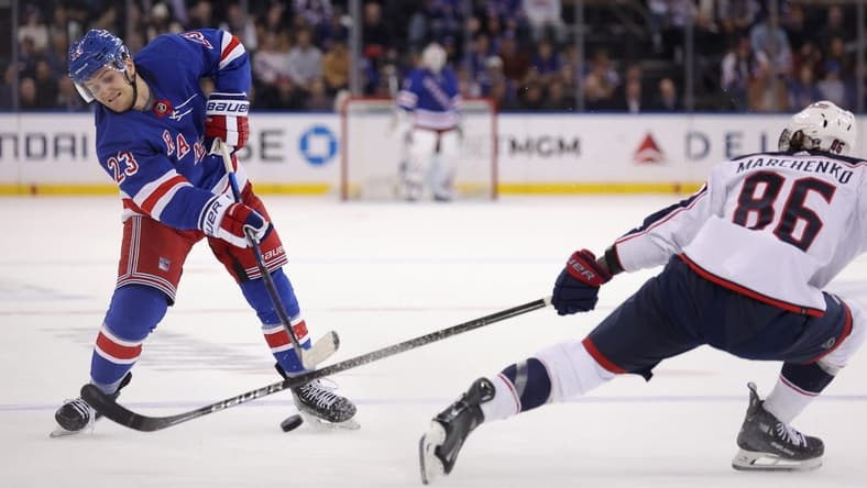 Feb 28, 2024; New York, New York, USA; New York Rangers defenseman Adam Fox (23) takes a shot against Columbus Blue Jackets right wing Kirill Marchenko (86) during the second period at Madison Square Garden. Mandatory Credit: Brad Penner-USA TODAY Sports