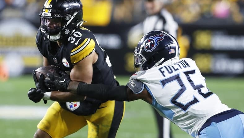 Nov 2, 2023; Pittsburgh, Pennsylvania, USA;  Pittsburgh Steelers running back Jaylen Warren (30) runs against Tennessee Titans cornerback Kristian Fulton (26) during the third quarter at Acrisure Stadium. Pittsburgh won 20-16. Mandatory Credit: Charles LeClaire-USA TODAY Sports