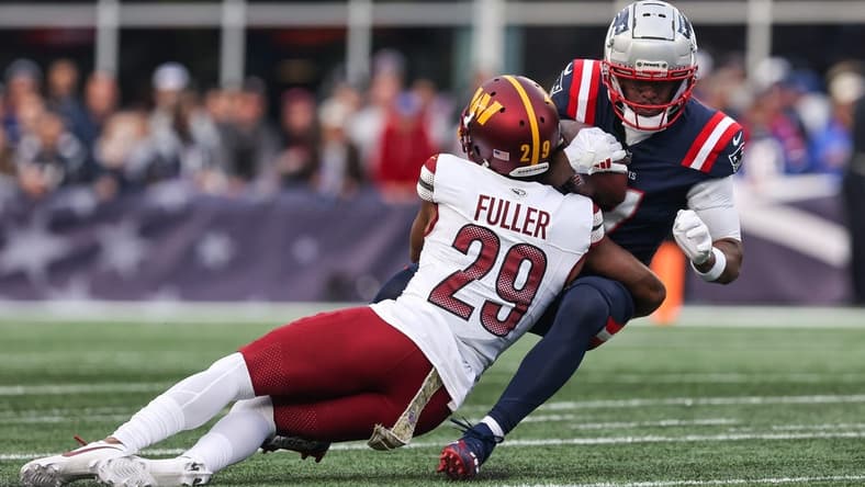 Nov 5, 2023; Foxborough, Massachusetts, USA; Washington Commanders cornerback Kendall Fuller (29) tackles New England Patriots receiver JuJu Smith-Schuster (7) during the second half at Gillette Stadium. Mandatory Credit: Paul Rutherford-USA TODAY Sports