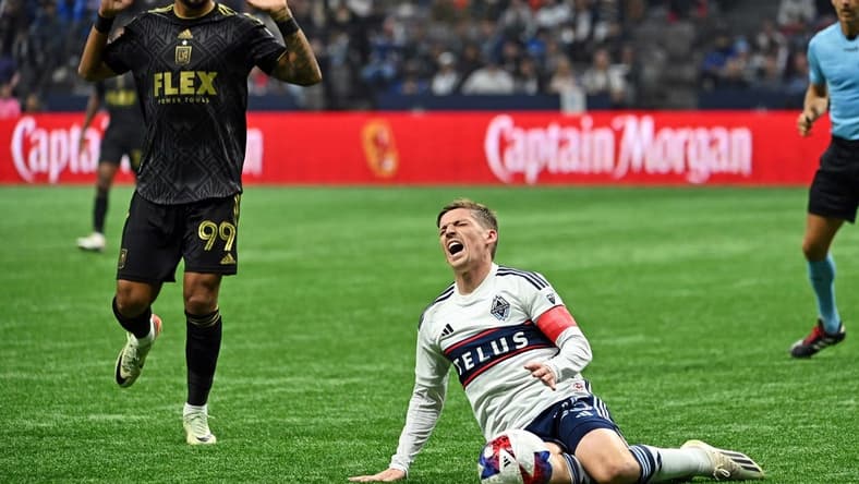 Nov 5, 2023; Vancouver, British Columbia, CAN; Vancouver Whitecaps midfielder Ryan Gauld (25) falls to the pitch against Los Angeles FC forward Denis Bouanga (99) during the second half of game two in a round one match of the 2023 MLS Cup Playoffs at BC Place. Mandatory Credit: Simon Fearn-USA TODAY Sports