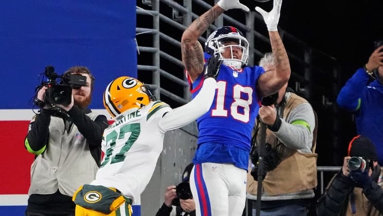 Dec 11, 2023; East Rutherford, New Jersey, USA; New York Giants wide receiver Isaiah Hodgins (18) catches a touchdown against Green Bay Packers cornerback Carrington Valentine (37) during the third quarter at MetLife Stadium. Mandatory Credit: Robert Deutsch-USA TODAY Sports