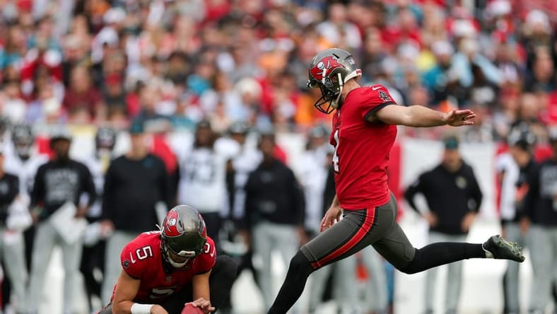 Dec 24, 2023; Tampa, Florida, USA;  Tampa Bay Buccaneers place kicker Chase McLaughlin (4) kicks a field goal held by punter Jake Camarda (5) against the Jacksonville Jaguars in the first quarter at Raymond James Stadium. Mandatory Credit: Nathan Ray Seebeck-USA TODAY Sports