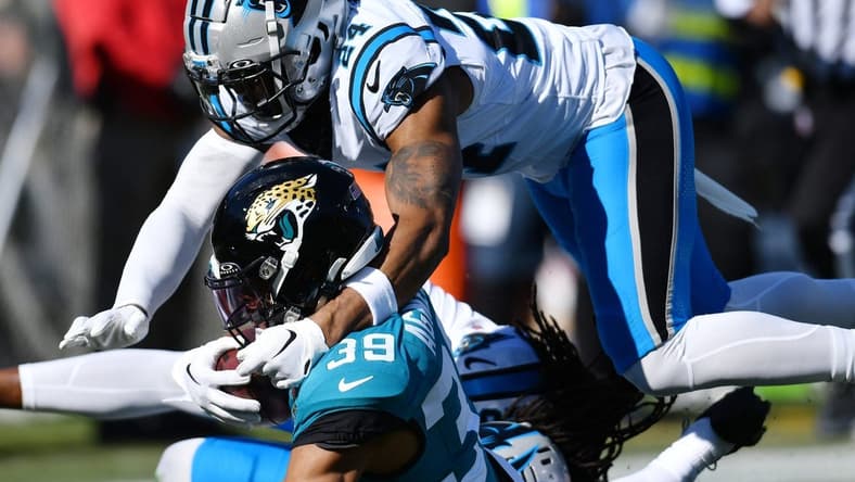 Jacksonville Jaguars wide receiver Jamal Agnew (39) gets tackled by Carolina Panthers cornerback Shaquill Griffin (20) and safety Vonn Bell (24) on a first down pass play to the 5-yard line late in the second quarter. Agnew was injured at the end of the play. The Jacksonville Jaguars hosted the Carolina Panthers at EverBank Stadium in Jacksonville, FL Sunday, December 31, 2023. The Jaguars went in at the half with a 9 to 0 lead. [Bob Self/Florida Times-Union]