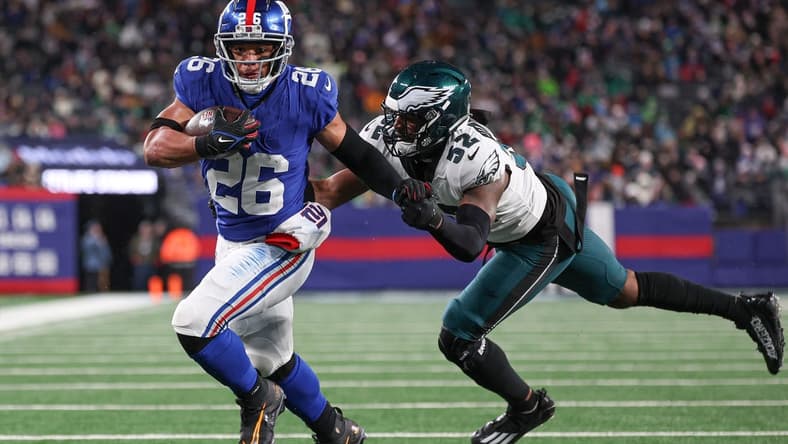 Jan 7, 2024; East Rutherford, New Jersey, USA; New York Giants running back Saquon Barkley (26) breaks a tackle by Philadelphia Eagles linebacker Zach Cunningham (52) for a rushing touchdown during the first half at MetLife Stadium. Mandatory Credit: Vincent Carchietta-USA TODAY Sports