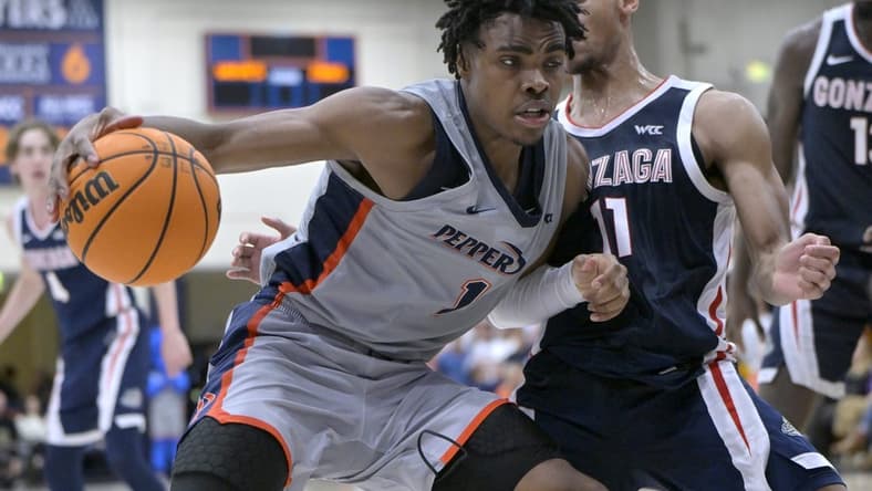 Jan 18, 2024; Malibu, California, USA; Pepperdine Waves guard Michael Ajayi (1) is defended by Gonzaga Bulldogs guard Nolan Hickman (11) in the second half at Firestone Fieldhouse. Mandatory Credit: Jayne Kamin-Oncea-USA TODAY Sports