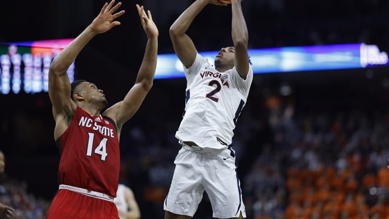 Jan 24, 2024; Charlottesville, Virginia, USA; Virginia Cavaliers guard Reece Beekman (2) shoots the ball as North Carolina State Wolfpack guard Casey Morsell (14) defends in overtime at John Paul Jones Arena. Mandatory Credit: Geoff Burke-USA TODAY Sports