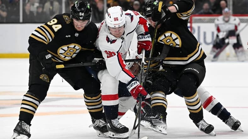 Feb 10, 2024; Boston, Massachusetts, USA; Washington Capitals right wing Nicolas Aube-Kubel (96) battles for the puck against Boston Bruins center Jakub Lauko (94) and center Morgan Geekie (39) during the second period at the TD Garden. Mandatory Credit: Brian Fluharty-USA TODAY Sports