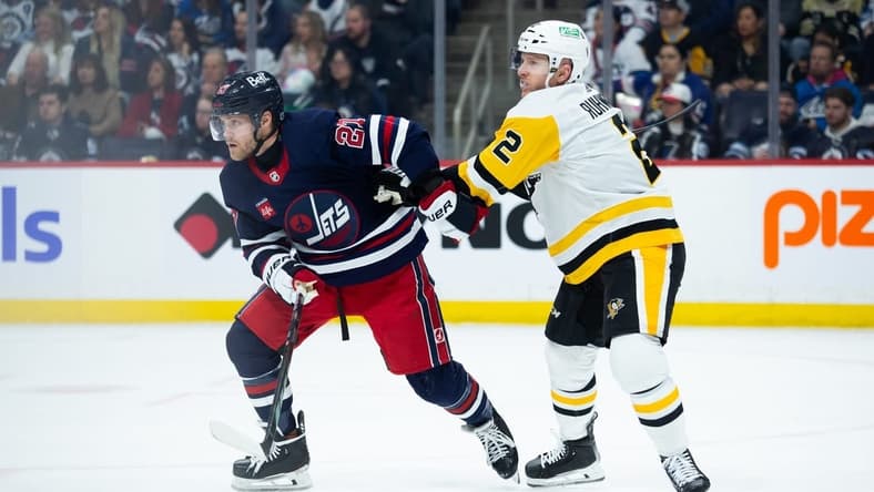 Feb 10, 2024; Winnipeg, Manitoba, CAN;  Pittsburgh Penguins defenseman Chad Ruhwedel (2) jostles for position with Winnipeg Jets forward Nikolaj Ehlers (27) during the second period at Canada Life Centre. Mandatory Credit: Terrence Lee-USA TODAY Sports
