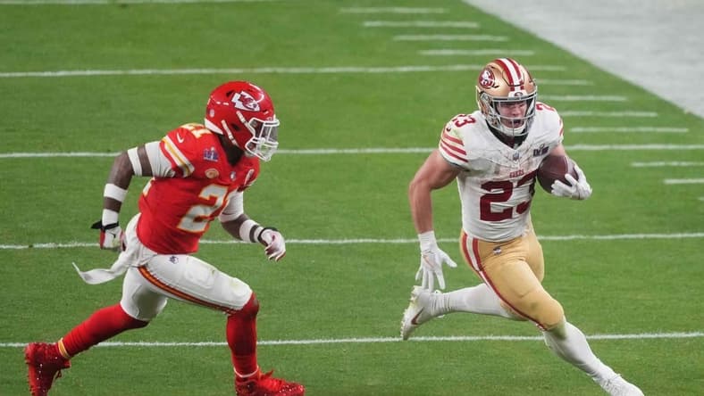 Feb 11, 2024; Paradise, Nevada, USA; San Francisco 49ers running back Christian McCaffrey (23) runs with the ball against Kansas City Chiefs safety Mike Edwards (21) during overtime of Super Bowl LVIII at Allegiant Stadium. Mandatory Credit: Joe Camporeale-USA TODAY Sports